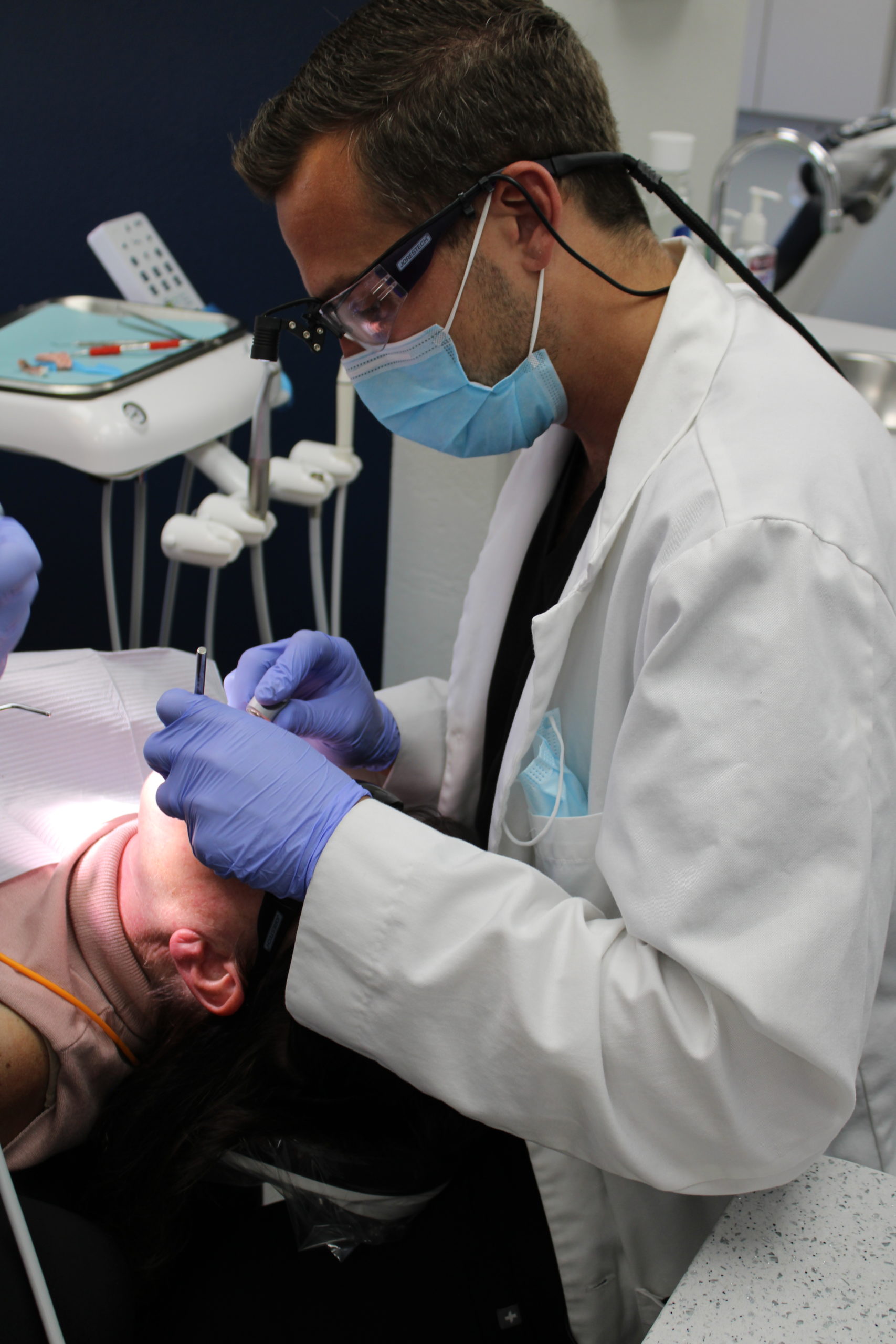 Dr. Dylan McKnight cleaning a patients teeth in westminster, co